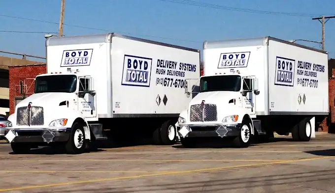Side angle of Boyd Total delivery trucks parked in a row with company branding