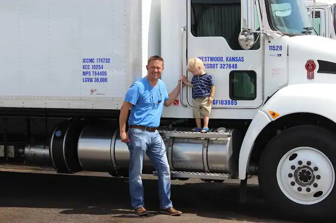 Boyd Total truck with two generations of leadership standing beside cab, symbolizing family legacy
